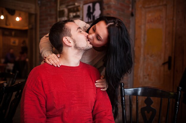 Girl kissing man in cafe