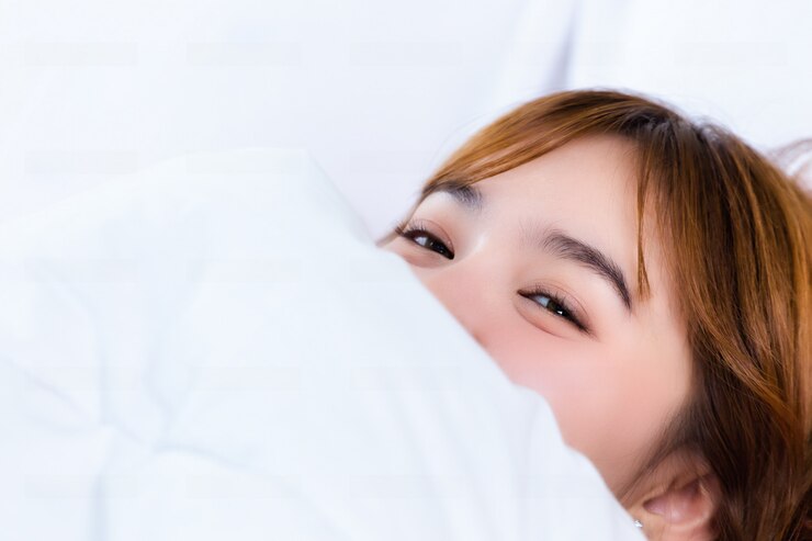 무료 Photo 여자는 흰 담요 아래 침대에 누워