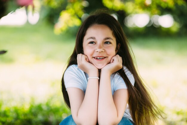 Girl leaning on hands sitting outside