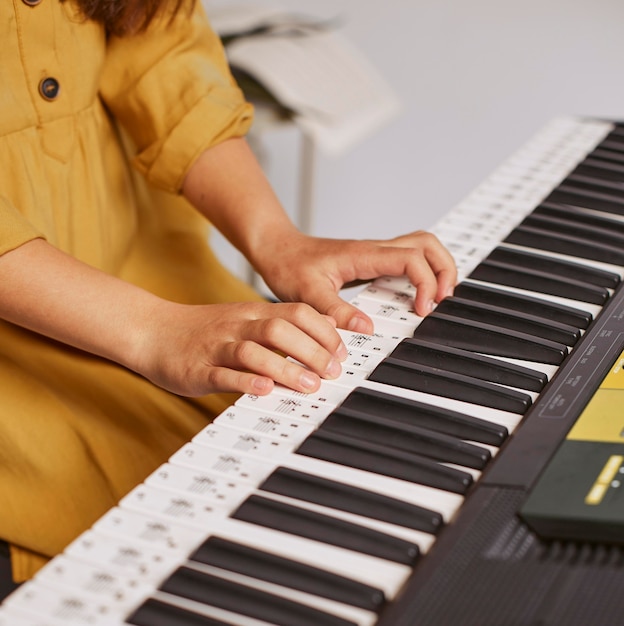 전자 키보드를 연주하는 방법을 배우는 소녀