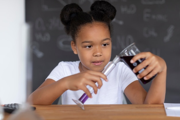 수업 시간에 화학에 대해 더 많이 배우는 소녀