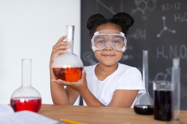 Foto gratuita ragazza che impara di più sulla chimica in classe