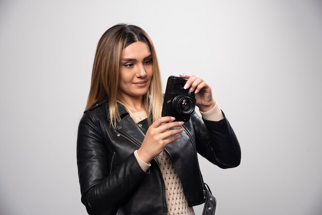 Girl in leather jacket checking her photo history on the camera