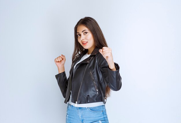 Girl in leather jacket showing her fists. 