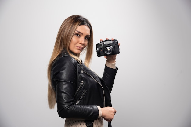 Free photo girl in leather jacket taking her photos in elegant and positive positions.