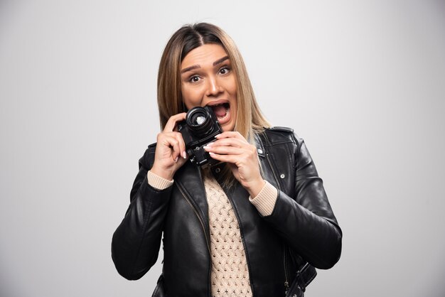 Girl in leather jacket taking her photos in funny and strange positions.