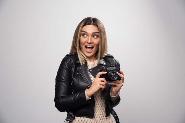 Girl in leather jacket taking her photos in funny and strange positions