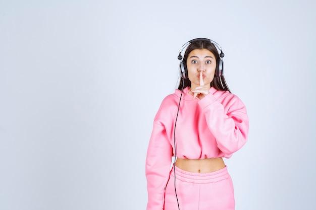 Girl listening the headphones and asking for silence. High quality photo