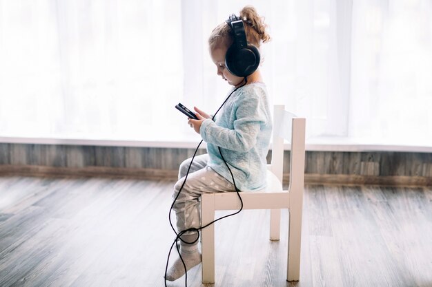 Девушка слушает музыку на стуле
