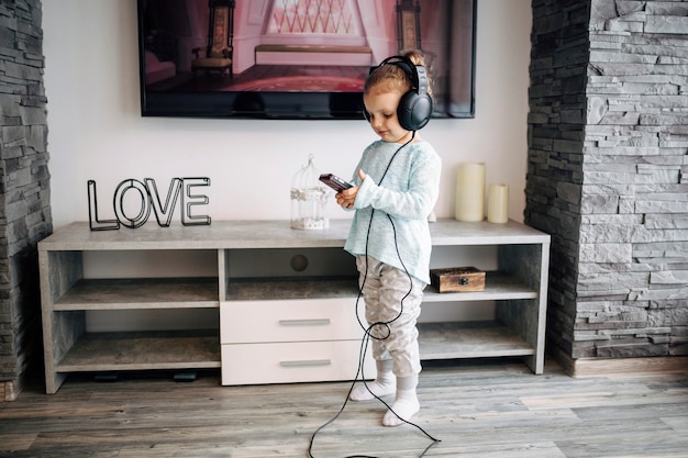 Free photo girl listening to music near tv