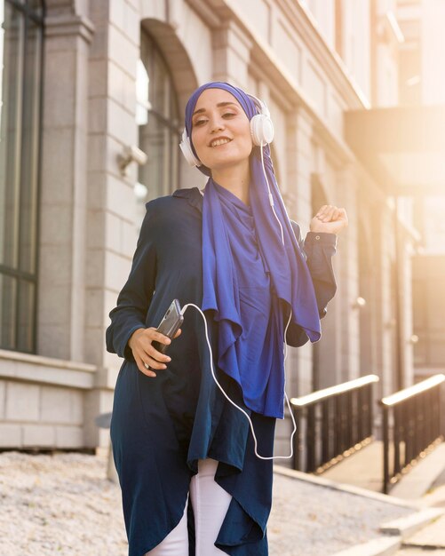 Girl listening to music through headphones outside