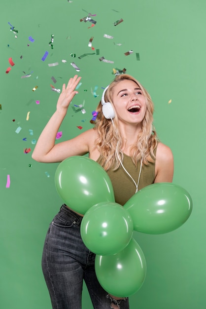 Бесплатное фото Девушка слушает музыку и держит воздушные шары