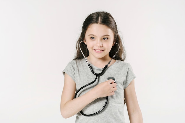 Girl listening with stethoscope in studio