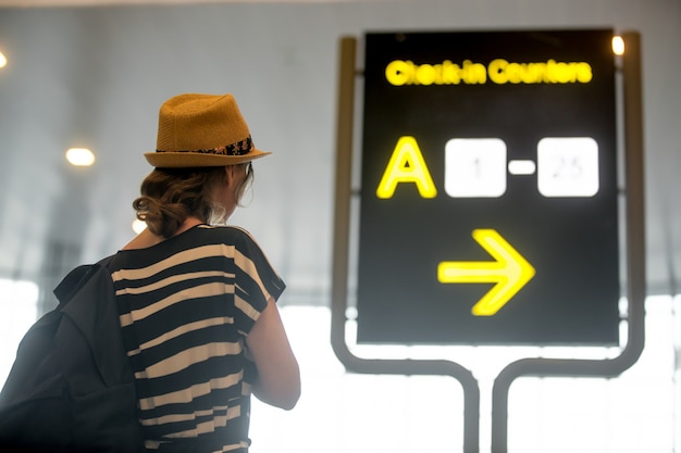 Foto gratuita ragazza che guarda la scheda di informazioni dell'aeroporto