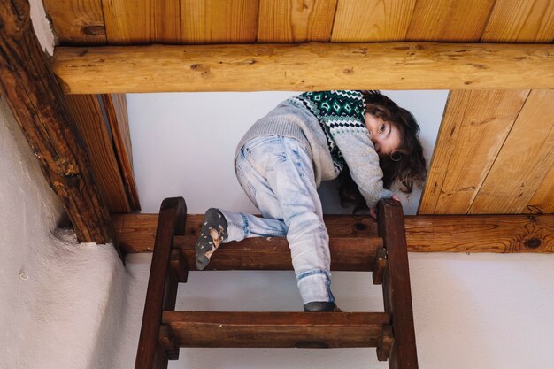 Девушка, глядя на камеру во время подъема лестницы