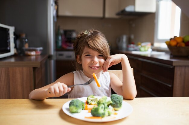 野菜を食べながらカメラ目線の女の子