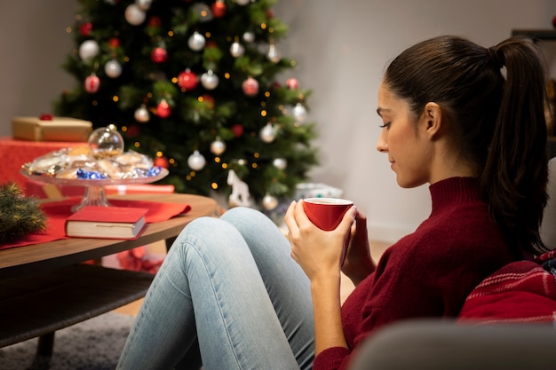 Girl looking at a cup with a christmas background