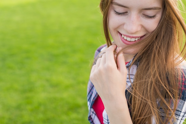 Foto gratuita ragazza che osserva giù mentre sorridendo