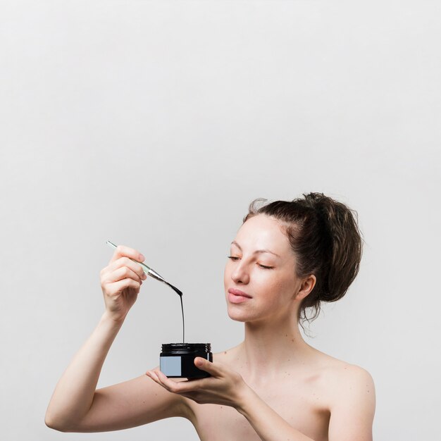 Girl looking at face mask jar