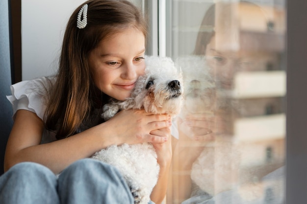 Girl looking out the window with her dog