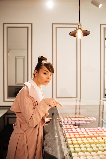 Girl looking at pastries through glass showcase at the cafe