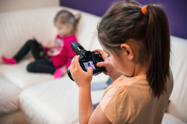 Free photo girl looking at pictures of sister