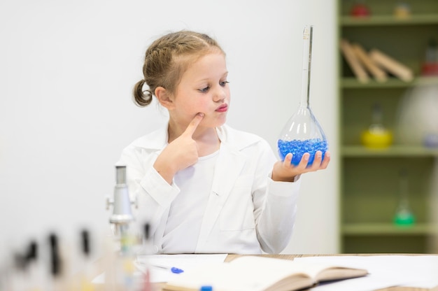 Ragazza che esamina il tubo di scienza