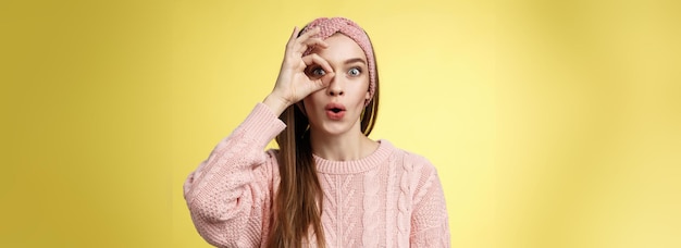 Free photo girl looking through circle from hand amazed excited folding lips amused and thrilled of awesome