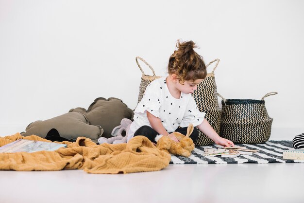 Girl looking at toys on striped rag