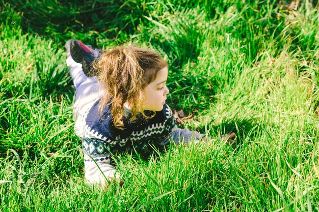 Girl lying on grass and looking away