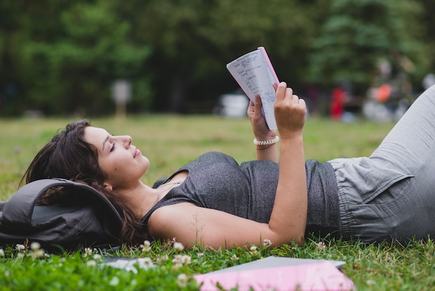 Девушка лежала на траве в парке чтения