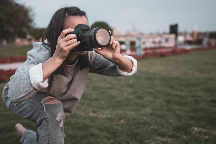 Free Photo girl makes a photo on a professional slr camera in the summer outdoors.