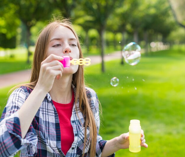 Девушка делает мыльные пузыри на улице
