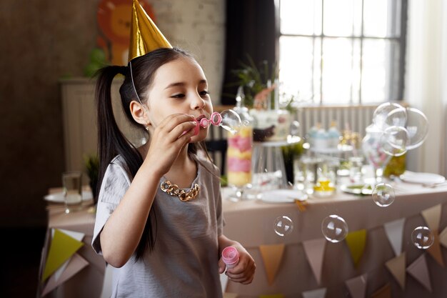 Girl making soap bubbles side view