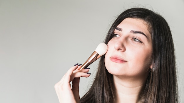 Girl making up her cheeks