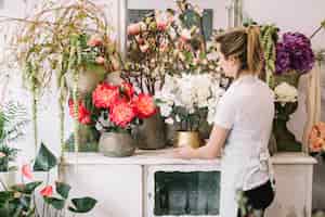 Foto gratuita ragazza che fa composizione floreale meravigliosa in negozio