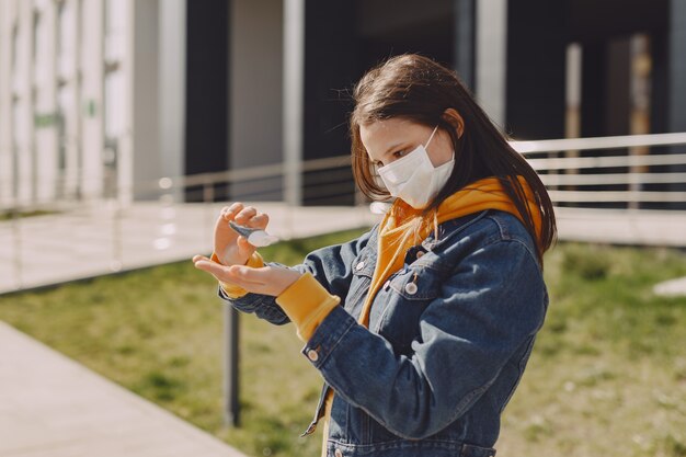 Girl in a mask stands on the street