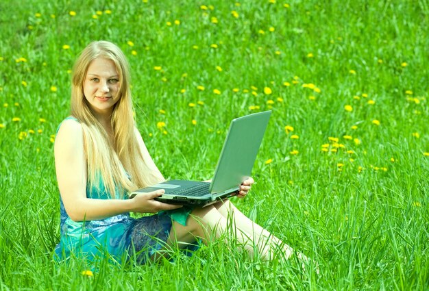 girl  on meadow with laptop