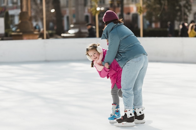 Девочка и мать на коньках вместе