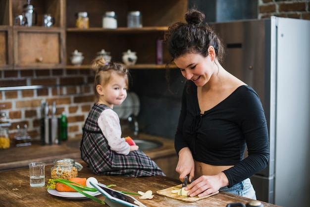 Free photo girl near woman cutting apple