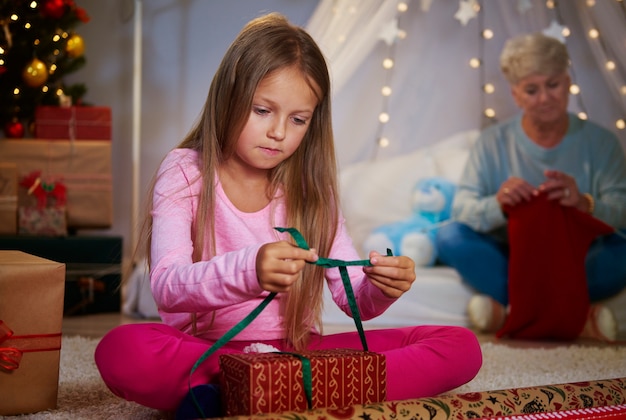 Ragazza che confeziona un regalo di natale