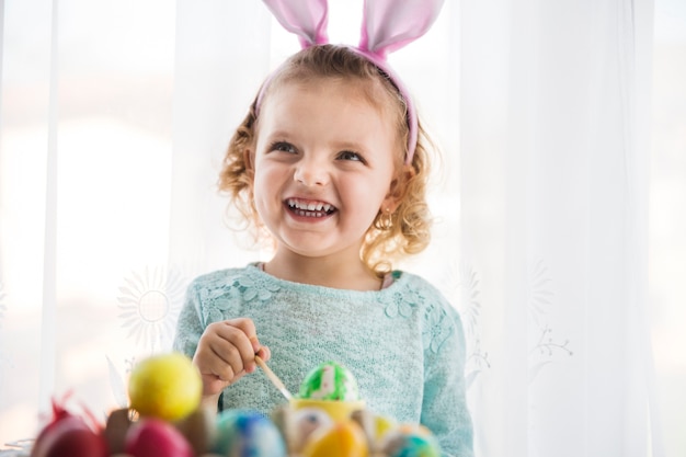 Free photo girl painting egg and looking up