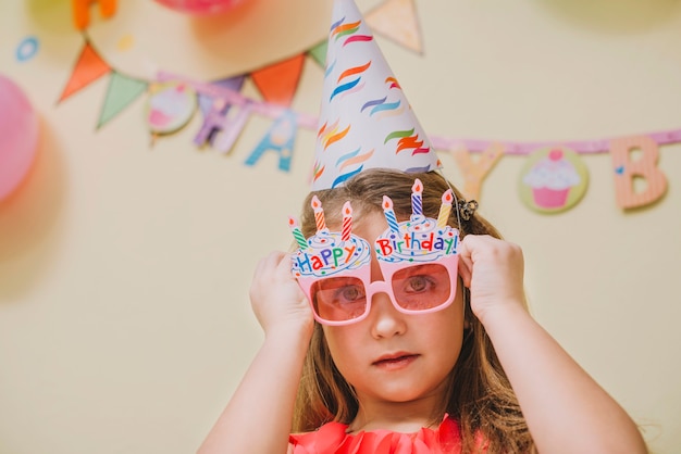 Girl in party glasses celebrating birthday