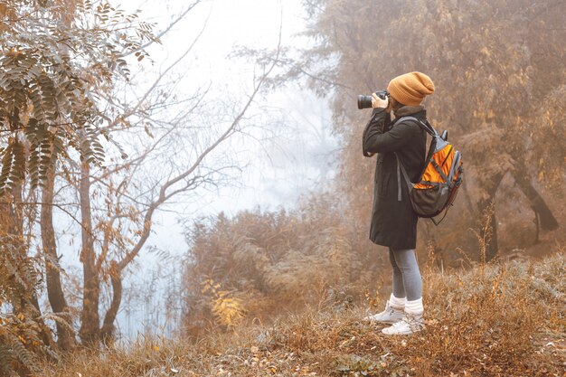 Premium Photo | Girl photographer takes pictures of autumn nature.