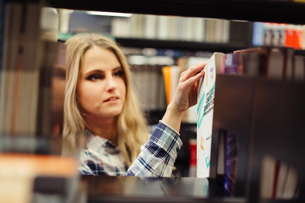 girl picking book in library