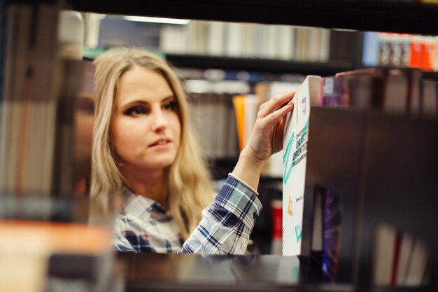 Girl picking book in library