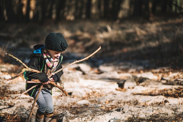 Girl picking branches in woods