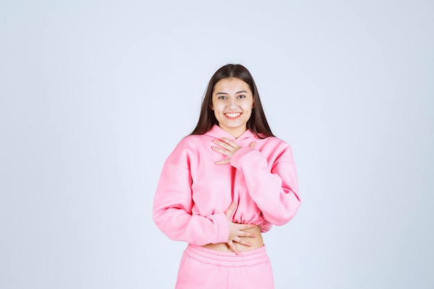 Девушка в розовой пижаме дает противные и веселые позы