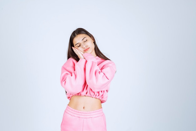 Free photo girl in pink pajamas looks sleepy