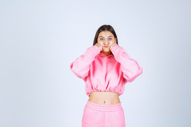 Girl in pink pajamas looks sportive and shows her fists